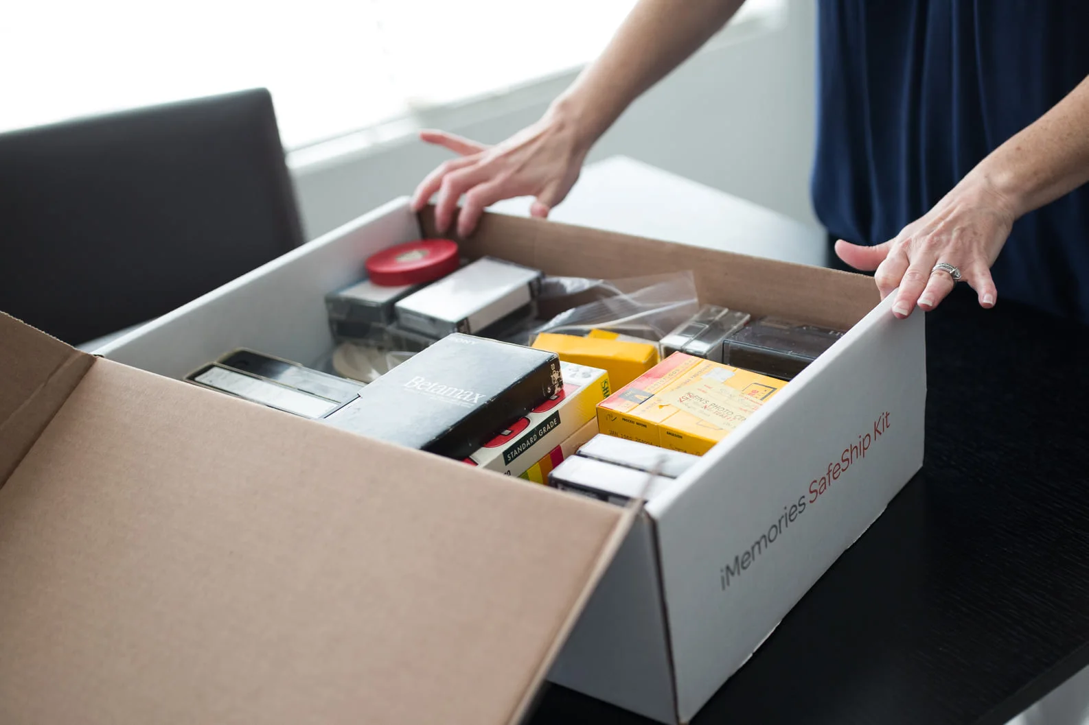VHS tapes, film reel, photos, and slides on a table